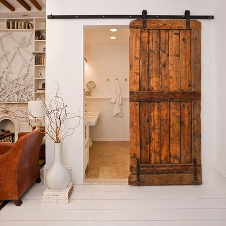 Reclaimed timber fencing is re-worked into a sliding barn-style door
