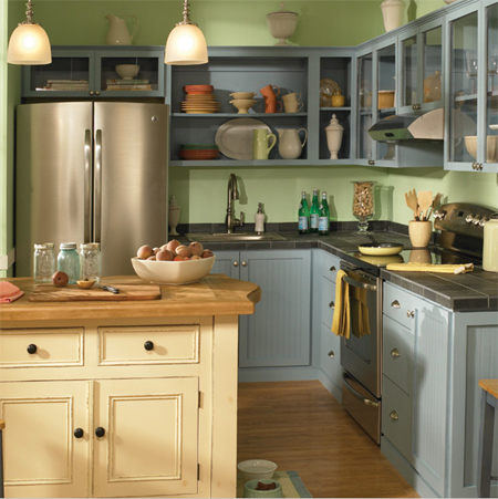 This rustic cottage kitchen has pale blue cabinets that mix it up with cream cabinets and pale green walls