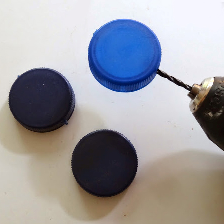 drill a hole top and bottom of plastic bottle caps and thread nylon line