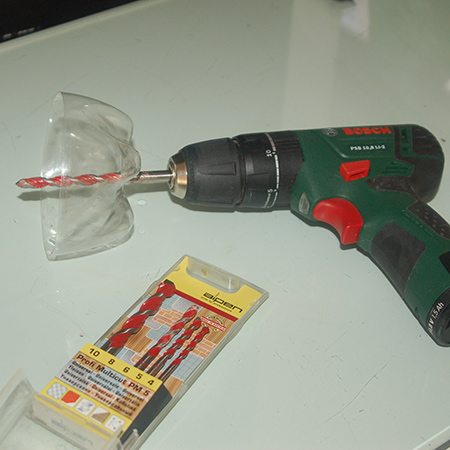 Recycle a plastic cold drink bottle into a dust catcher. A clear plastic bottle allows you to see where you are drilling