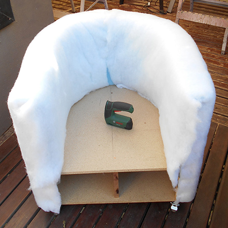 I managed to tuck the batting around the inside of the bottom - tucked underneath the foam cladding. Allow extra batting to fold over the front of the armrests.