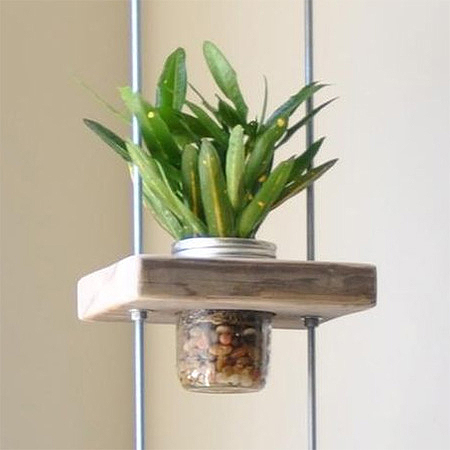 Make this vertical planter using blocks of reclaimed wood, threaded rods and nuts, and some recycled food jars or mason jars.