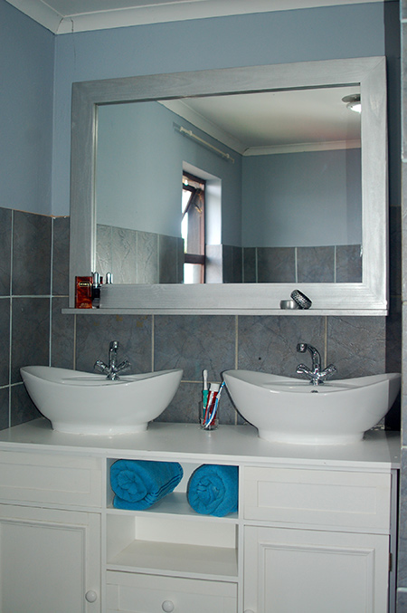 Give your bathroom a designer touch with a framed bathroom mirror and storage shelf