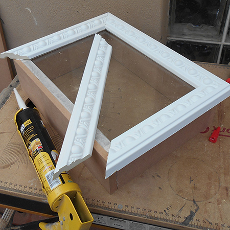 7. Glue the front frame by applying a liberal bead of adhesive to the top edges of the box and also to the edges of the moulding. Press the frame or moulding firmly in place making sure the edges are nicely joined together.