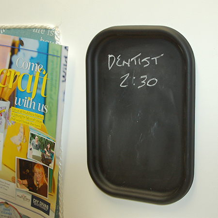 The mini chalkboard is made using a lid from an ice cream tub. The lid is sprayed with a couple of coats of Rust-Oleum Chalkboard spray paint and hot-glued onto the pinboard frame.