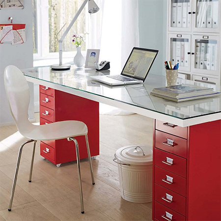 This modern desk is made using a couple of secondhand filing cabinets, a glass top, and an inexpensive hollow core door.
