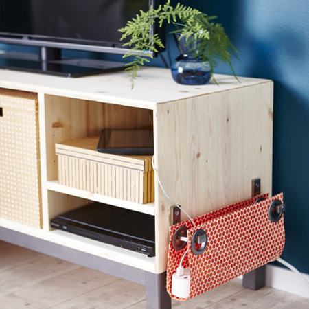 TV units are another area where power cords and cables can cause clutter. The fabric covered pouch [above] is perfect for holding a cable adaptor so that you never have to crawl under furniture again.