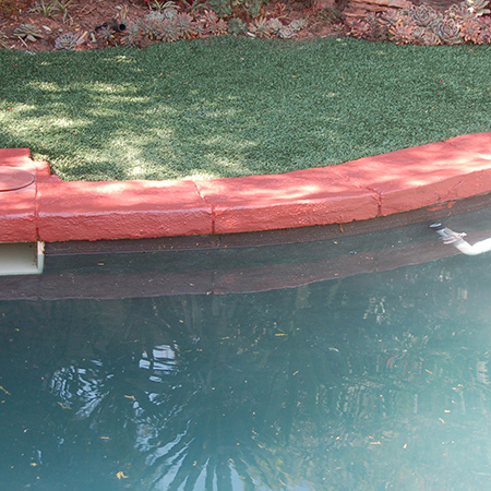 Prominent Paints paving paint is applied to the pool surround to cover up hard water and mineral deposit stains.