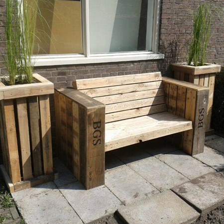Reclaimed wood pallet bench is framed by pallet flower boxes