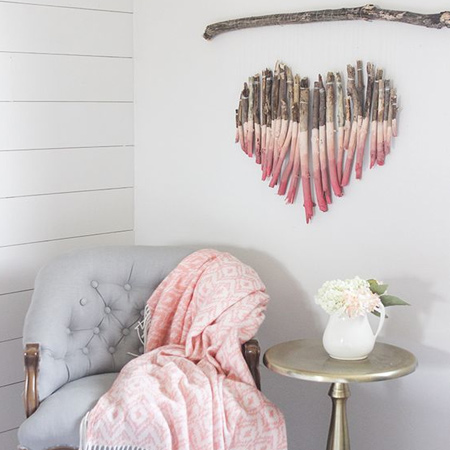 After trimming back trees or large shrubs, using these to make unique decor for the home is fun and adds a unique feature to any wall. The heart-shaped wall decor below is given a pink ombre paint treatment and suspended from a larger branch on thin string.