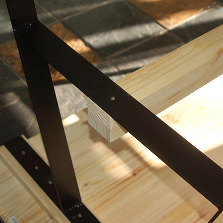 Place the tabletop face down in order to mount the steel leg frames onto the crossbeam using 4,5 x 50mm screws. 