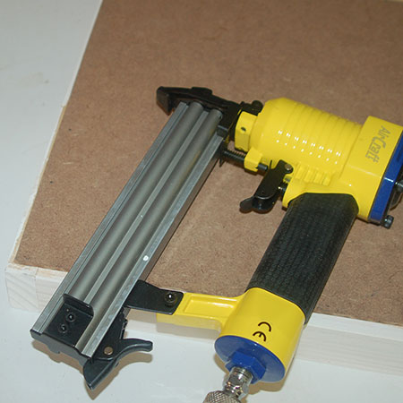 Secure the backing board with brad nails. If you don't over a brad nailer, use a hammer and panel pins or a heavy-duty stapler.