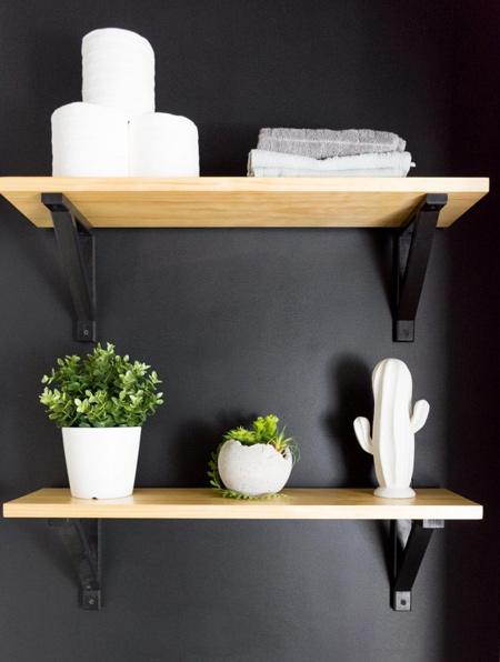 Simple pine shelves steal the show when mounted on a flat black wall.