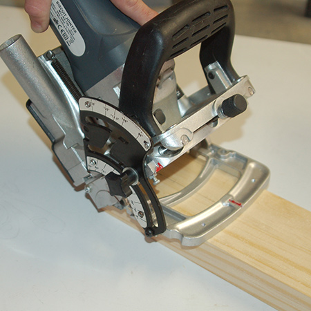 3. Set your biscuit joiner plate at a 45-degree angle to cut slots in the ends of the top sections and high side pieces.