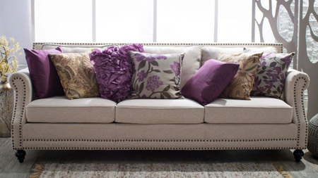 Add visual interest to a netural sofa by layering colour, texture and pattern.