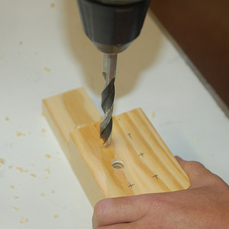5. Drill 10mm holes through the two block. Place a scrap piece underneath to protect your work surface.