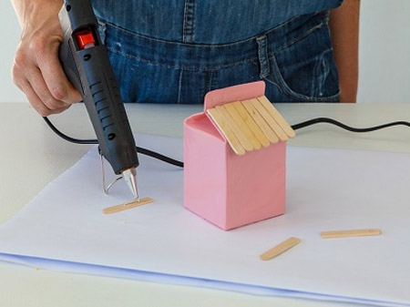 HOME-DZINE | Craft Ideas - Heat up the glue gun and apply a bead of glue to the ice cream sticks to make the roof of the bird feeder.