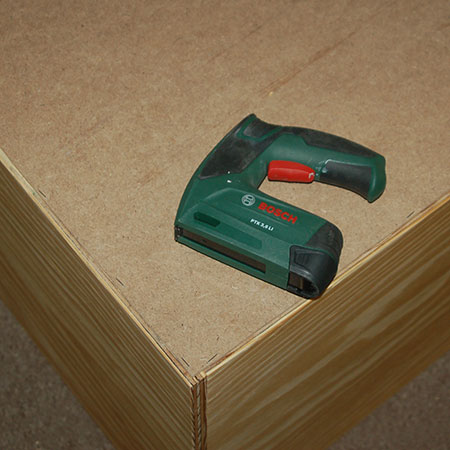 12. Secure the backing board in place with a Bosch Tacker, or hammer and panel pins. Turn upside down to attach the castor wheels to the base.