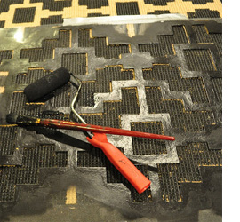 Use acrylic paint to stencil design on a rug or mat