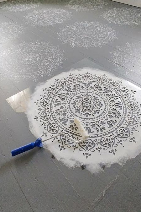 use masking tape to mark out design for painting wooden floor with checkerboard or chevron design