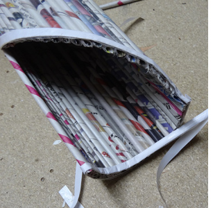 Rolled newspaper wine bottle holder 