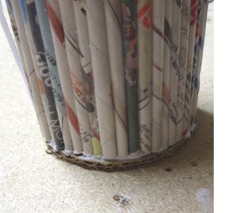 Rolled newspaper wine bottle holder