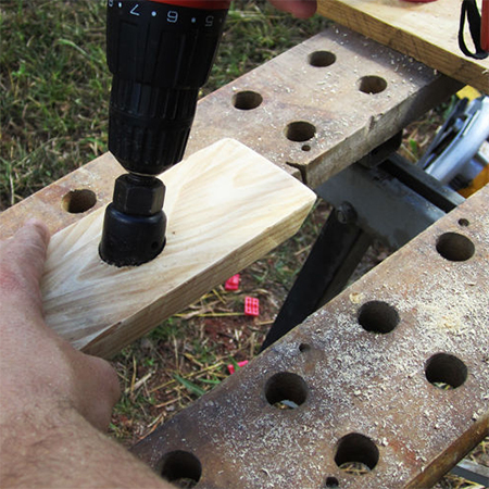 use hole saw to drill hole in reclaimed timber for wine rack