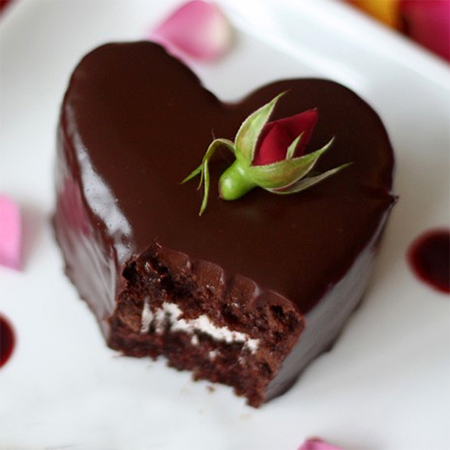 Valentine's dessert chocolate cake layers filled with a raspberry cream and covered in glossy chocolate ganache
