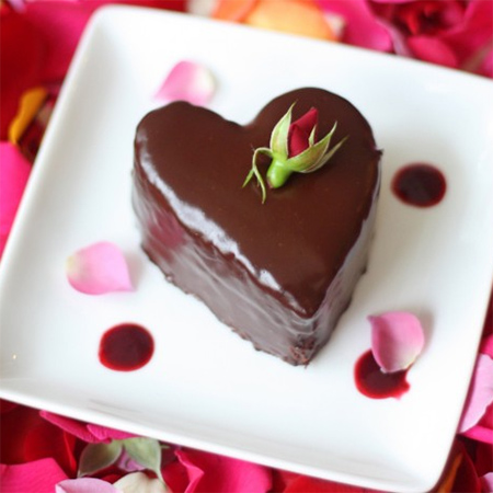 Valentine's dessert chocolate cake layers filled with a raspberry cream and covered in glossy chocolate ganache