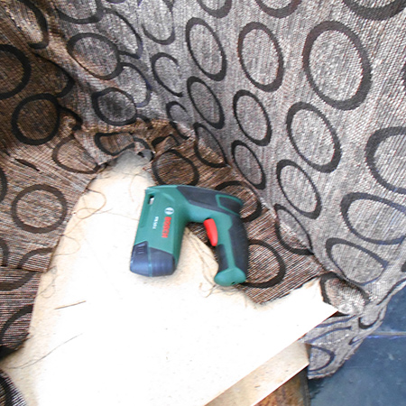 Now you can move to the inside and secure the fabric to the chair seat. Again, pull the fabric taut and staple to the seat as close to the side edge as possible.