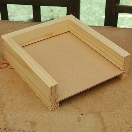 Attach one end piece to the sides and leave one end open to slip in the masonite / hardboard base.
