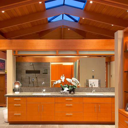 Granite tops in a mottled grey feature and custom cabinets in both bathrooms carry through the theme from other rooms in this family home.