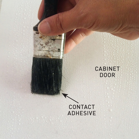 Apply a layer of contact adhesive to both the doors and the back of each piece of veneer. Allow to dry until slightly tacking before sticking the veneer onto the doors. 