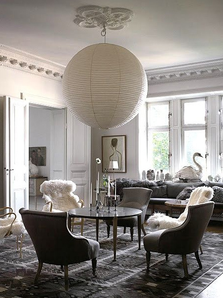 an oversized chinese paper lantern set over a dining table sets the mood