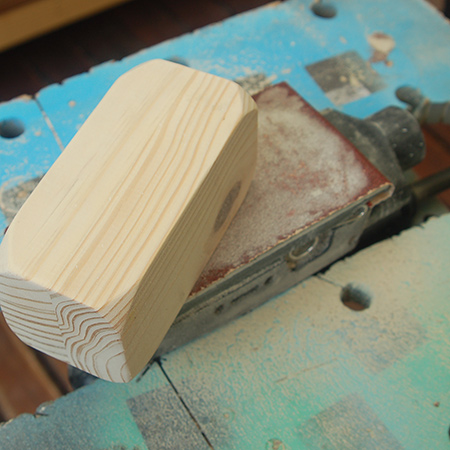 Lock your sander upside down in a clamping workbench. In this way you can use both hands to move the project around on the sandpaper