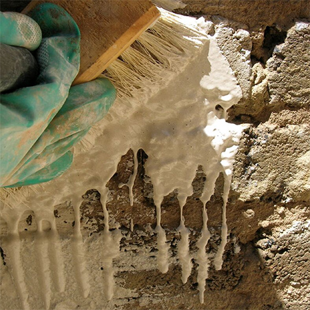5. Combine 2 parts PermaStop with 1 part water and mix to a paintable consistency. Damp down the surface and then apply a liberal coat of PermaStop over the wall, using a whitewashing brush to ensure that the surface is completely covered.