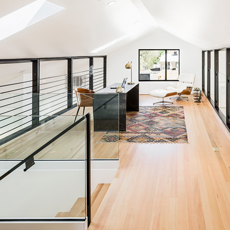 The stairs from the lower to upper level have transparent glass sides and the steel and wire balustrade around the loft provides safety without imposing on the visual flow throughout the open areas.