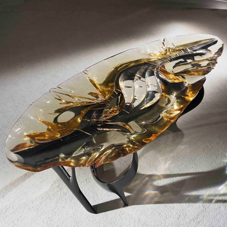 Lumenoria has cast resin over a free-form ash sculptural base, allowing the liquid resin to respond to the wood form beneath creating an undulating, organic three-dimensional form. The carving process for the base mirrors the natural material and conforms it to a form that is appealing to the touch, like that of a pebble that has been eroded in a stream.