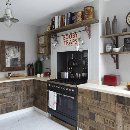 This rustic kitchen features a variety of reclaimed wood products. Love the crates and pallets repurposed as kitchen cabinet doors