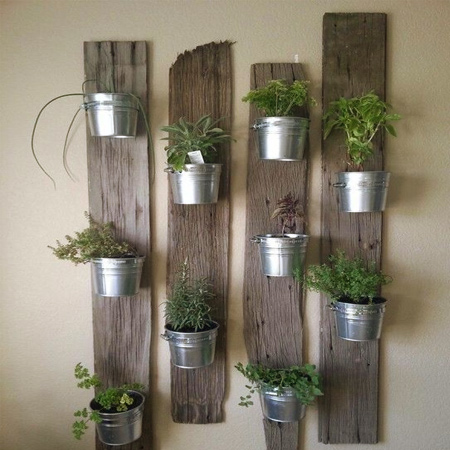 Reclaimed fence boards are re-purposed into an interesting arrangement for galvanised pots filled with assorted herbs for the kitchen.