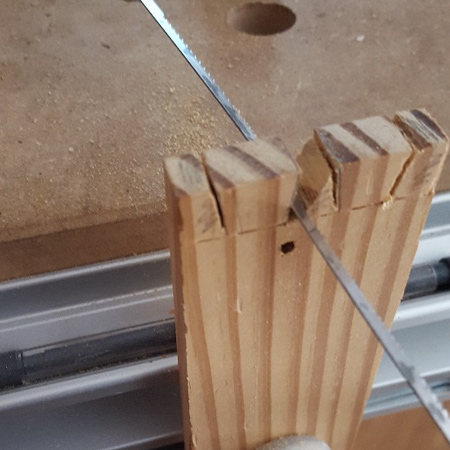 3. Use a fine kerf saw or scroll saw to cut the tails. You can then use a thin wood chisel to clean the faces. The kerf or scroll saw is also used to cut away the half pins on the edge of the board. 