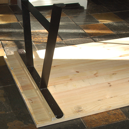 Place the tabletop face down in order to mount the steel leg frames onto the crossbeam using 4,5 x 50mm screws. 