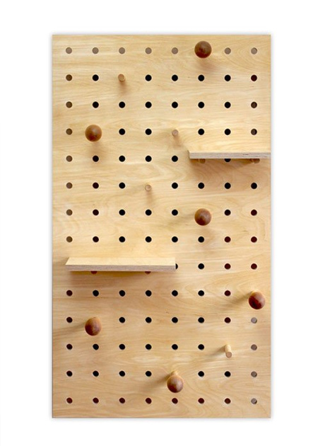 Amazing how something so simple can be so practical. Have a piece of veneered plywood or marine plywood cut to the required size. Measure and mark the location for drilling the holes with a spade bit or MAD bit, making sure that the position of the holes allows for the size of any shelves.