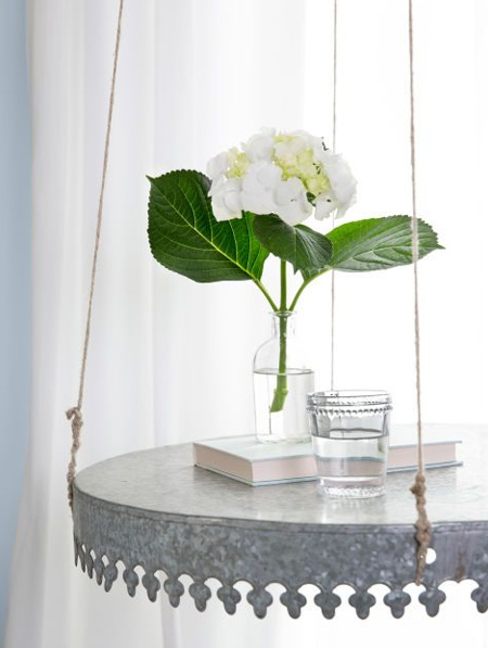 A galvanised steel tray with decorative edging is turned upside down for a pretty hanging table