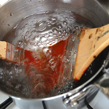 Fill an old, deep saucepan with hot water and a tablespoon of vinegar - rest the brushes bristles down and boil for a few minutes