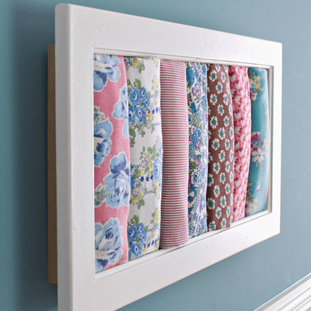 Rolled remnants of colourful, printed fabric mounted in a shadowbox frame