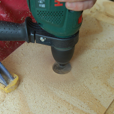 Clamp the board firmly to your workbench and then use a drill and 35mm Forstner bit to drill a hole 60mm in from the front edge for the wineglass holder.