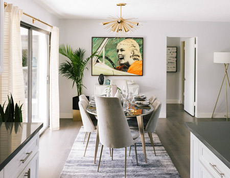 While art itself is a feature, there's nothing wrong with adding a little more impact by hanging art about an accent piece of furniture. In this dining area the artwork sits directly above a geometrical West Elm console table, creating its own focal point within the space.