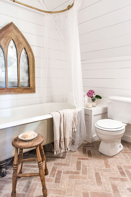 brick pavers in a herringbone pattern are laid on the bathroom floor