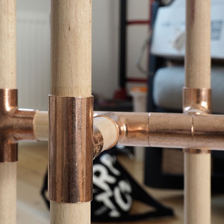 close up of pine dowel plant stand with copper fittings